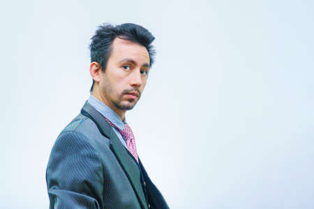 Funny unshaven man in suit with tie on gray backgroundの写真素材