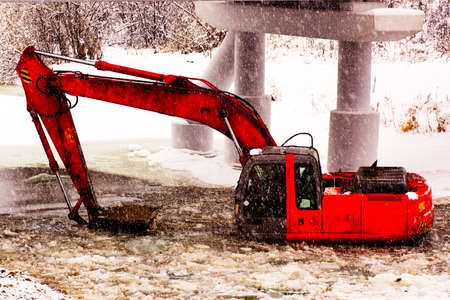 Hard work. Carrying excavator repairs to strengthen the shore near the bridgeの写真素材