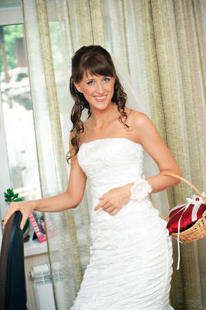 The beautiful bride in a white dress smiles and looks in cameraの写真素材