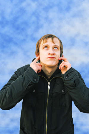 young man in jacket calls by phone  Connection is bad の写真素材