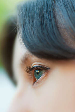 closeup woman open green eye with eyelashの写真素材