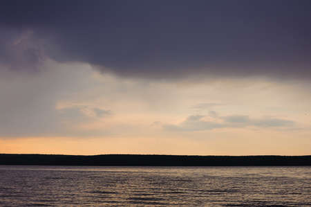 waves on a river in evening time with storm cloudsの写真素材