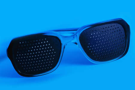 medical spectacles with hole in blue backgrounds. This colour not computer effect. It is dark blue illumination lampの写真素材