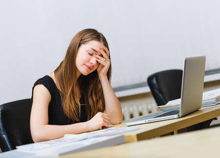 sitting pensive tired woman working of notebook computerの写真素材