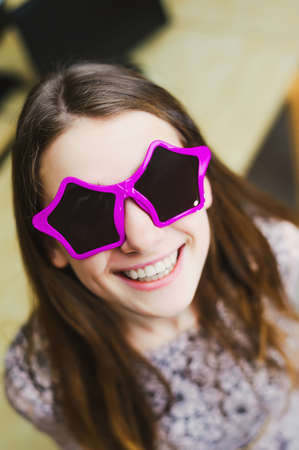 face of cheerful smile positive young woman in stars glassesの写真素材