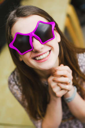 face of cheerful smile positive young woman in stars glassesの写真素材