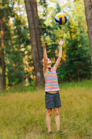 girl throwing a ball on nature backgroundsの写真素材