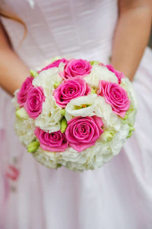 beauty wedding bouquet of red and white roses in a bride handsの写真素材