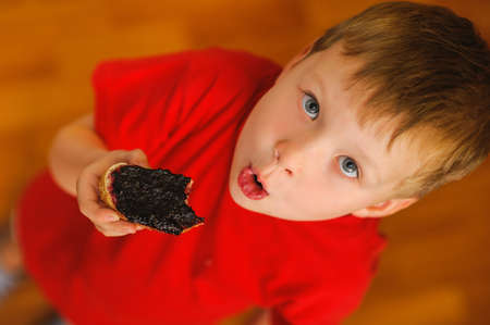 kid eating tasty bread with bilberry jamの写真素材