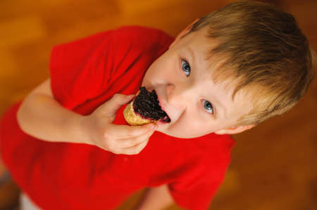 kid eating tasty bread with bilberry jamの写真素材