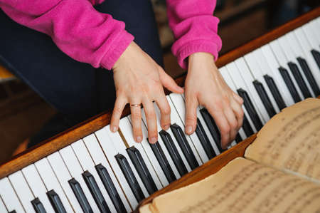 woman hands on a piano key. Playing music. selective focus techniqueの写真素材