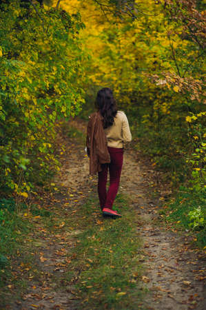 woman walk in autumn forestの写真素材