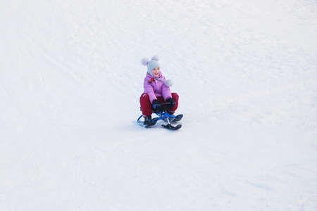 girl motion on a snow scooter. small motion blur effect from speedの写真素材