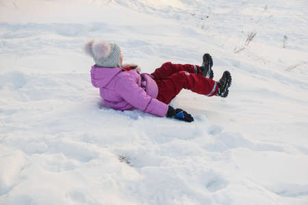 girl motion climb down on a snow hillの写真素材