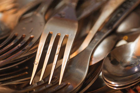 closeup wet shiny forks and spoons after wash upの写真素材