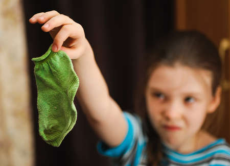 kid find and holding crumpled one sockの写真素材