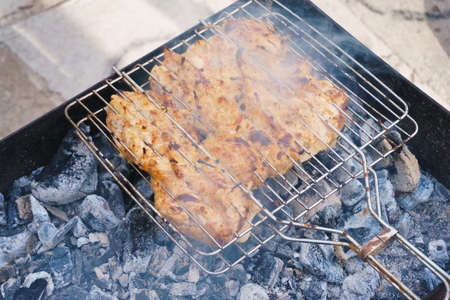 many chicken roast meat pieces with onion on grillの写真素材