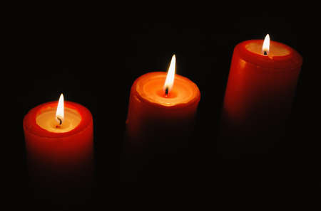 Beautiful candles burning on black backgroundsの写真素材