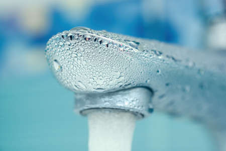 water drops on the faucet in the bathroom. Macro photo. freshness and cleanliness. Selective focus.の写真素材