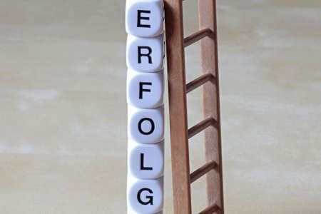 letter cubes with the word success and a ladder that leans on the cubesの写真素材