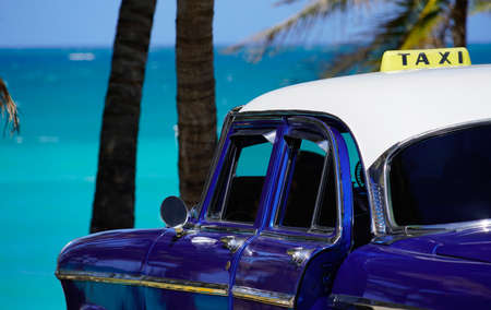 oldtimer taxi car in front of palm trees at the caribbean sea in cubaの写真素材