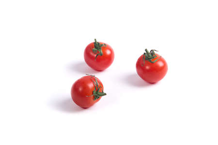 Three cherry tomatoes without a sprig on a white surfaceの写真素材