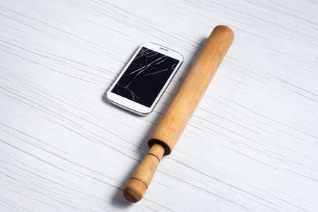 phone with broken glass and rolling pinの写真素材