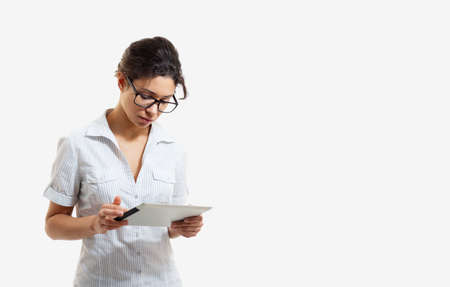 Portrait of a young beautiful woman in glasses with a tablet on a white backgroundの写真素材