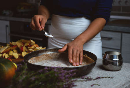 Preparation, Thanksgiving Celebration. A cook prepares to pour sugar from a silver spoon onto the dough for the apple pie.の写真素材