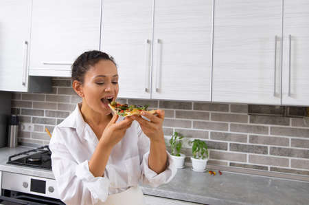 The young female chef prepares to taste her own vegan pizza without cheese.