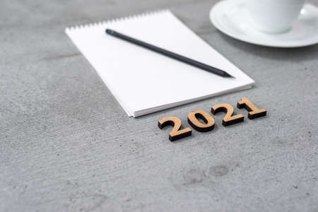 New Year 2021. Still life of the office space with notepad, pencil and cup on a gray surface.の写真素材
