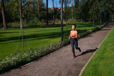 The young woman jogging along the park path. Outdoor sports.の写真素材