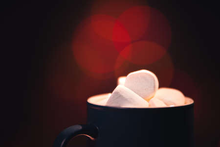 Still life. Close-up. The cup with marshmallows on a background of colored lights.の写真素材