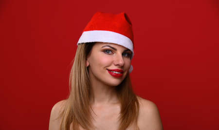 The young woman in a Santa hat smiles. The concept for the new year and Christmas.の写真素材
