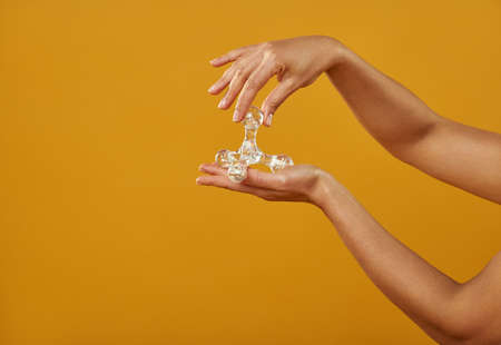 Isolated hands on yellow background with a pharaoh massager.の写真素材