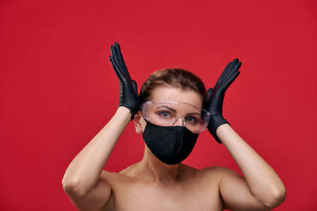 A woman in black gloves, medical mask and glasses grabbed her head.