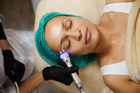 Performing massage with microcurrents in the cosmetology clinicの写真素材