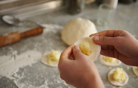 Close up of hands of woman making traditional vareniki or ravioli