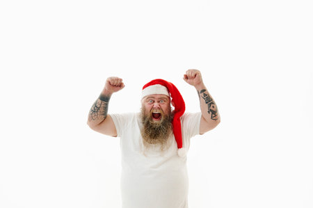 Isolated portrait on a white background of an overweigh man in Santa Claus hat expressing success, victory an goal achievementの写真素材