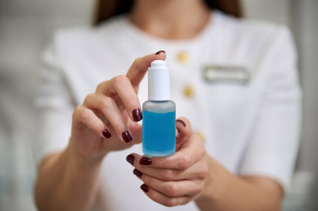 A beautiful brunette holding serum for face treatmentの写真素材