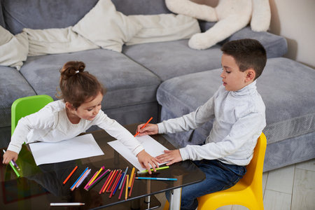 Brother and sister playing and drawing at home. Two children spending time together . Family time.の写真素材