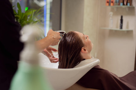 Young woman getting a hair wash in beauty salon . Concept of hair care and hair treatmentの写真素材