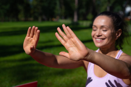 Selective focus on a woman smiling while taking sunbathing and enjoying sunny day outdoorの写真素材