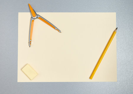 Top view of yellow tools for drawing. Pencil, compass, eraser and sheet of paperの写真素材