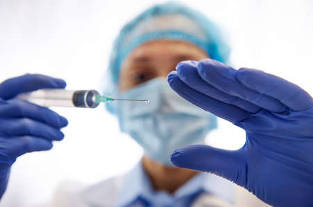 Doctor with a syringe ready to vaccinate population isolated on white background. Vaccination day....