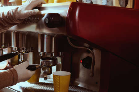 Closeup of female barista hand holding ground coffee for preparing espresso.の写真素材