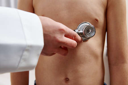 Pediatrician listens to a patient with a stethoscope. Auscultation of lungs and heart in pediatric...