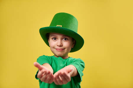 Boy in leprechaun Irish hat stretches his palms to the camera. Saint Patrick's Day concept.の写真素材