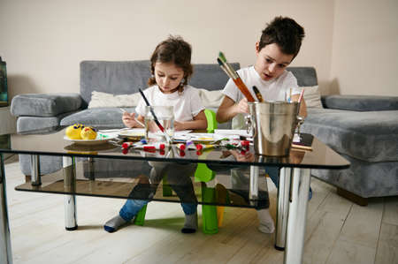 Two creatively adorable children, draw at home. Art lesson at home, Easter theme, watercolor technique. Art educationの写真素材