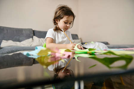 Adorable little girl focused on art creativity class at home. Preschool educationの写真素材